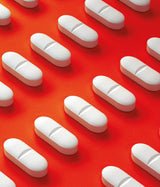 FLEXTRIN - MEDICAMENTO VITAMÍNICO. Pastillas formadas sobre fondo rojo.