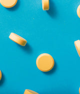 GLUTAMAX GOLD, Omega 3, Tirosina, Metionina, Ácido Glutámico, Complejo B y Vitamina C. Muestra de comprimidos sobre fondo Azul.