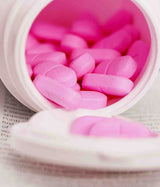 SENFEM NOVO - MEDICAMENTO VITAMÍNICO. Frasco abierto con píldoras sobre un periódico.