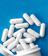 VALNAIT - MEDICAMENTO HERBOLARIO, Valeriana officinalis. Muestra de cápsulas sobre fondo azul.