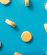 GLUTAMAX GOLD, Omega 3, Tirosina, Metionina, Ácido Glutámico, Complejo B y Vitamina C. Muestra de comprimidos sobre fondo Azul. 